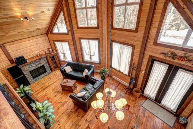 This is an example of a small country open concept living room in Charlotte with brown walls and painted wood floors.