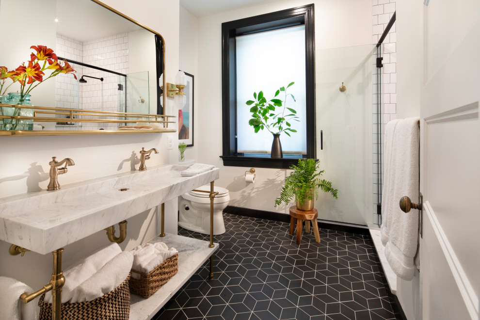 Adams Morgan Classic DC Rowhouse - The owners of this stately Adams Morgan rowhouse wanted to reconfigure rooms on the two upper levels  and to create a better layout for the nursery, guest room and au pair bathroom on the second floor. Our crews fully gutted and reframed the floors and walls of the front rooms, taking the opportunity of open walls to increase energy-efficiency with spray foam insulation at exposed exterior walls.

On the second floor, our designer was able to create a new bath in what was the sitting area outside the rear bedroom. A door from the hallway opens to the new bedroom/bathroom suite – perfect for guests or an au pair. This bathroom is also in keeping with the crisp black and white theme. The black geometric floor tile has white grout and the classic white subway tile is used again in the shower. The white marble console vanity has a trough-style sink with two faucets. The gold used for the mirror and light fixtures add a touch of shine.