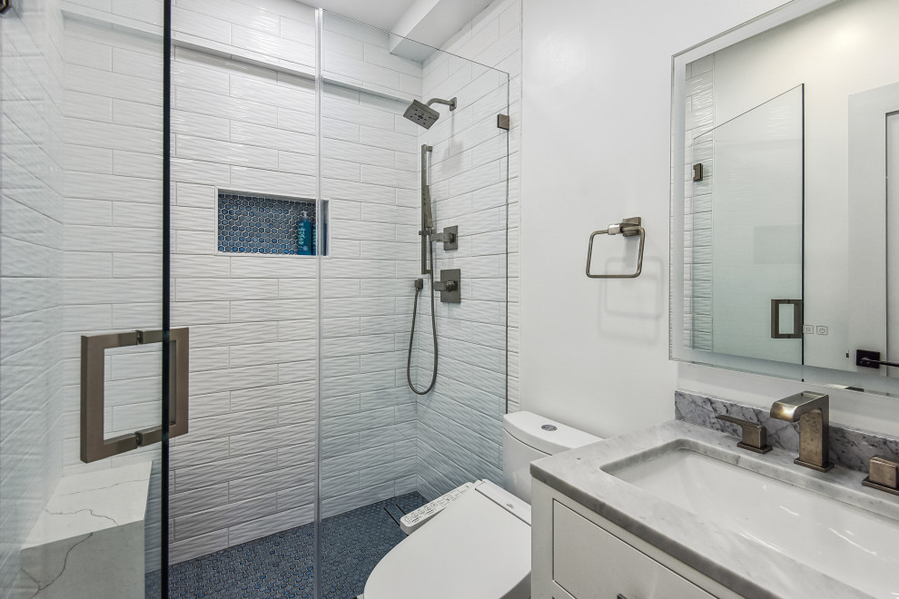 This is an example of a small transitional 3/4 bathroom in DC Metro with white cabinets, an alcove shower, a bidet, white tile, ceramic tile, white walls, ceramic floors, an undermount sink, engineered quartz benchtops, a hinged shower door, grey benchtops, a shower seat, a single vanity, a floating vanity and recessed-panel cabinets.