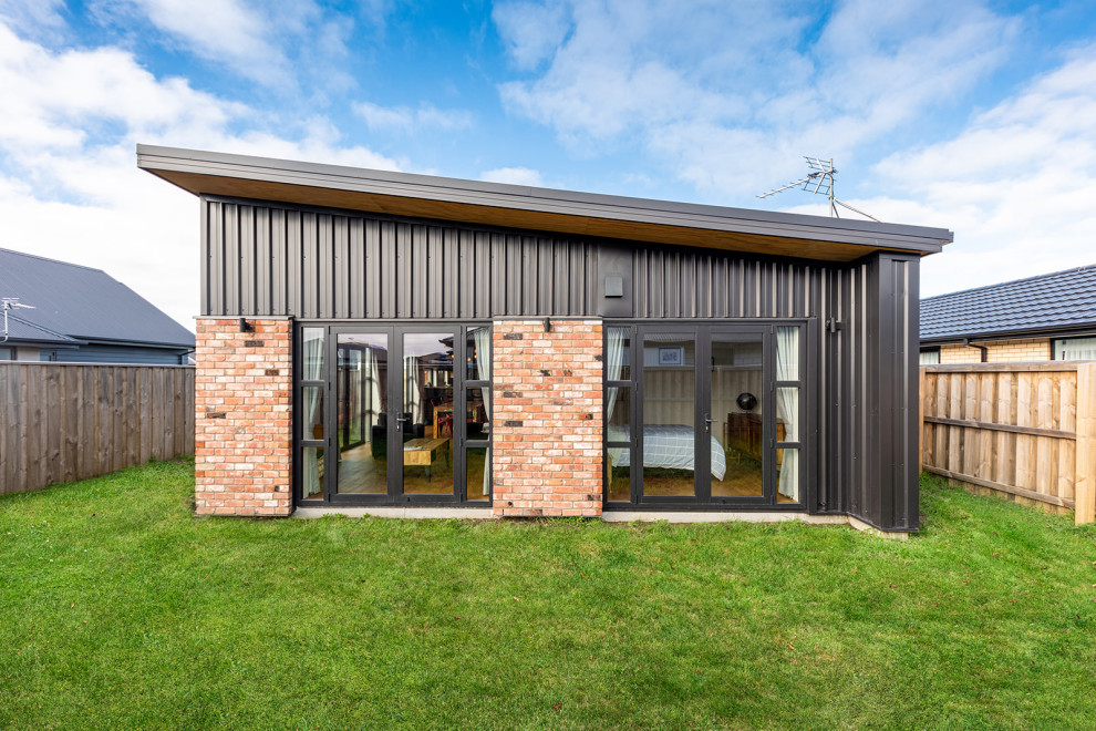 Idee per la villa piccola nera moderna a un piano con rivestimento in metallo, tetto a farfalla, copertura in metallo o lamiera e tetto nero