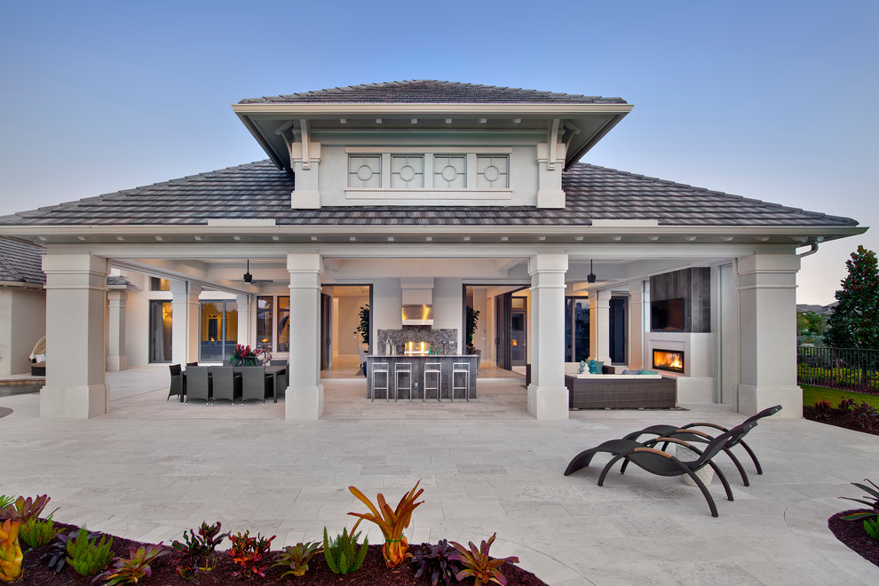 This is an example of a traditional backyard patio in Miami with an outdoor kitchen and a roof extension.