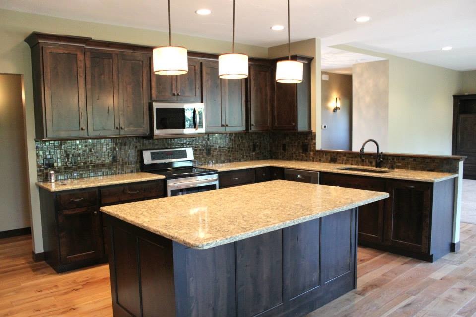 Example of a mid-sized transitional u-shaped light wood floor eat-in kitchen design with a double-bowl sink, raised-panel cabinets, dark wood cabinets, granite countertops, multicolored backsplash, matchstick tile backsplash, stainless steel appliances and an island
