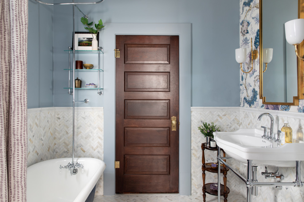 Klassisches Duschbad mit Duschbadewanne, weißen Fliesen, Mosaikfliesen, blauer Wandfarbe, Waschtischkonsole, weißem Boden, Duschvorhang-Duschabtrennung, Einzelwaschbecken, Tapetenwänden und Löwenfuß-Badewanne in Austin