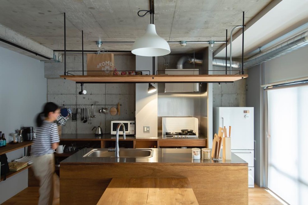 Photo of an industrial kitchen in Tokyo Suburbs with an integrated sink, open cabinets, medium wood cabinets, stainless steel benchtops, medium hardwood floors, with island and brown floor.