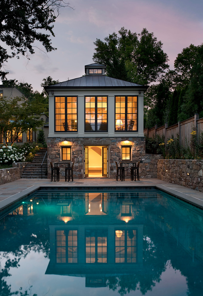 This is an example of a traditional rectangular pool in DC Metro with a pool house and natural stone pavers.