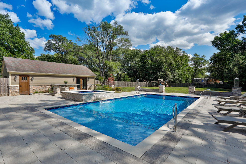 Photo of a mid-sized traditional backyard rectangular lap pool in Chicago with with a pool and natural stone pavers.