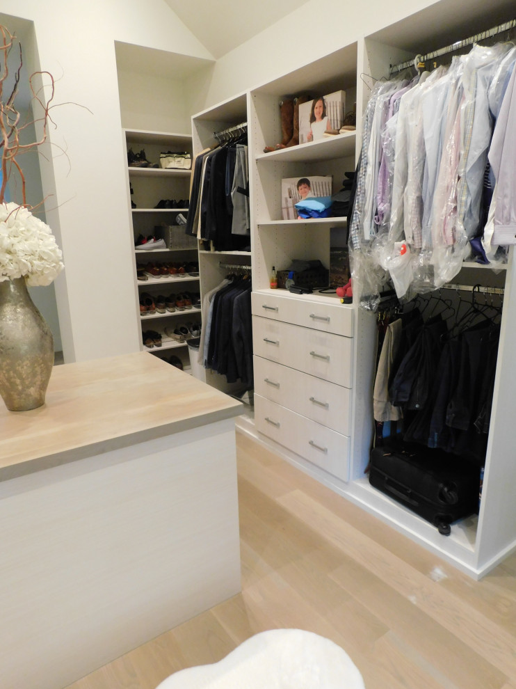 This is an example of a large contemporary walk-in wardrobe in Denver with open cabinets, white cabinets, medium hardwood floors, white floor and vaulted.