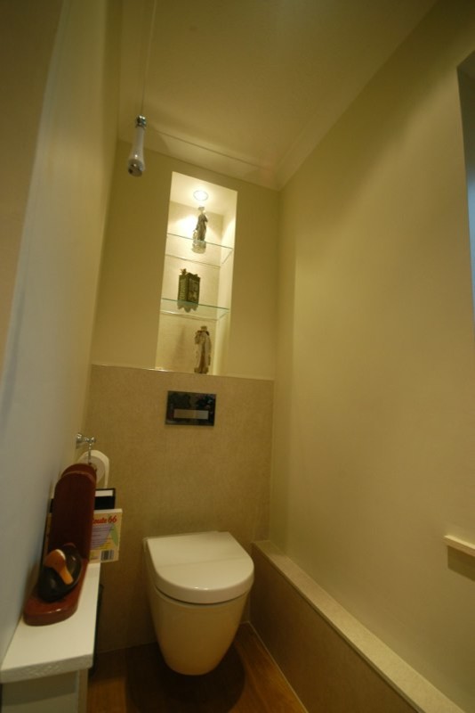 Cette image montre un petit WC suspendu traditionnel avec un carrelage beige, un mur beige, un sol en vinyl et un lavabo suspendu.