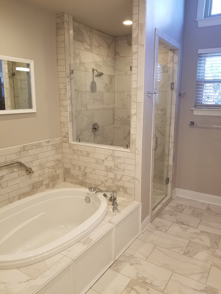 Inspiration for a mid-sized transitional master bathroom in New Orleans with recessed-panel cabinets, white cabinets, a drop-in tub, an alcove shower, a two-piece toilet, gray tile, white tile, porcelain tile, grey walls, porcelain floors, an undermount sink, engineered quartz benchtops, white floor and a hinged shower door.