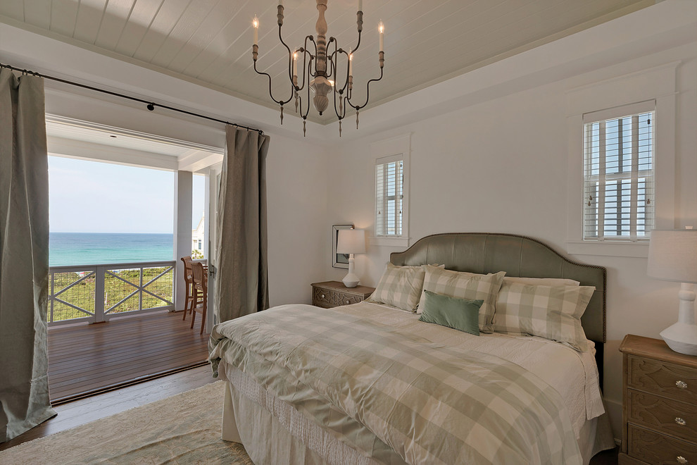 Mid-sized country guest bedroom in Miami with white walls, medium hardwood floors, no fireplace and beige floor.