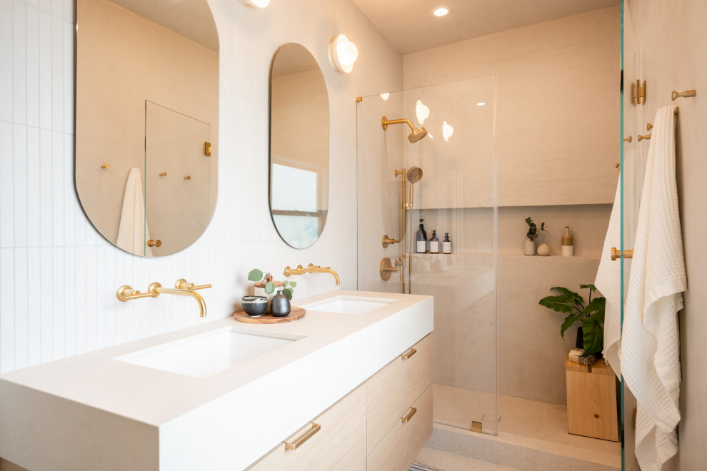 Inspiration for a medium sized scandi ensuite bathroom in San Francisco with flat-panel cabinets, an alcove shower, a wall mounted toilet, beige tiles, limestone tiles, beige walls, ceramic flooring, a submerged sink, engineered stone worktops, beige floors, a hinged door, beige worktops, a wall niche, double sinks and a floating vanity unit.