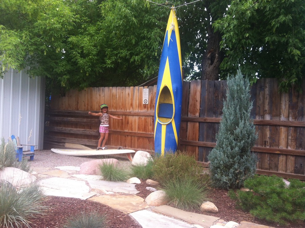Example of a mid-sized mountain style backyard stone patio design in Denver