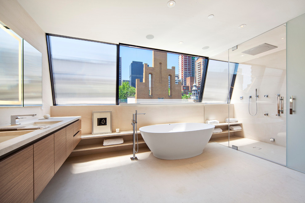 Contemporary master bathroom in New York with flat-panel cabinets, dark wood cabinets, a freestanding tub, a curbless shower, beige tile, beige walls, an integrated sink, beige floor and beige benchtops.