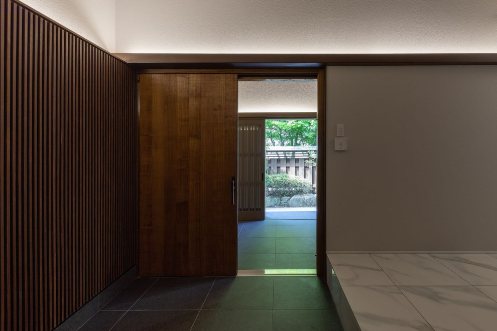 大阪にある高級なアジアンスタイルのおしゃれな玄関ホール (グレーの壁、セラミックタイルの床、茶色いドア、白い床、板張り天井、壁紙) の写真