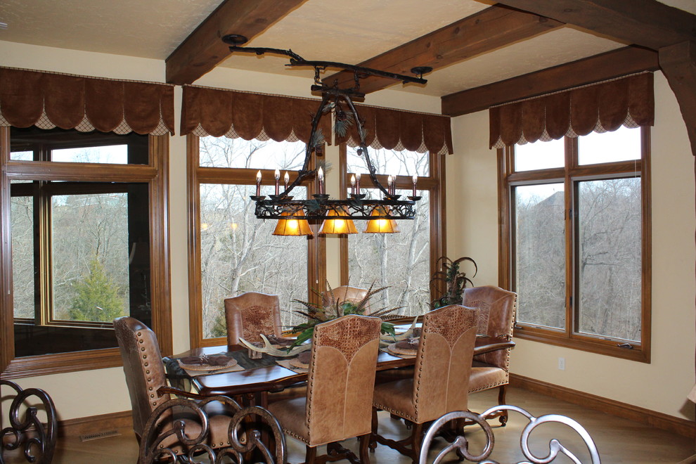 Photo of a mid-sized country separate dining room in Other with beige walls, medium hardwood floors, no fireplace and brown floor.