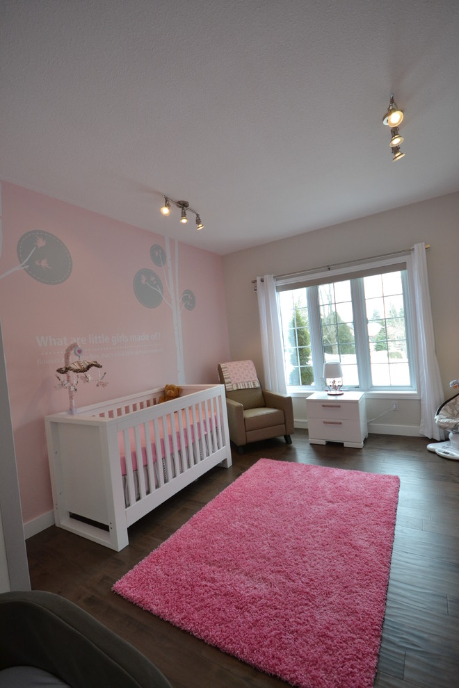 Photo of a modern nursery for girls in Other with pink walls.