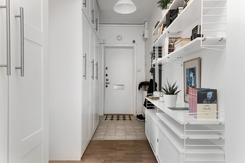 This is an example of a mid-sized scandinavian hallway in Stockholm with white walls.