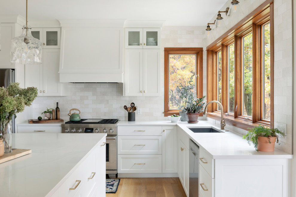 Design ideas for a transitional kitchen in Minneapolis with white cabinets, beige splashback, with island and white benchtop.