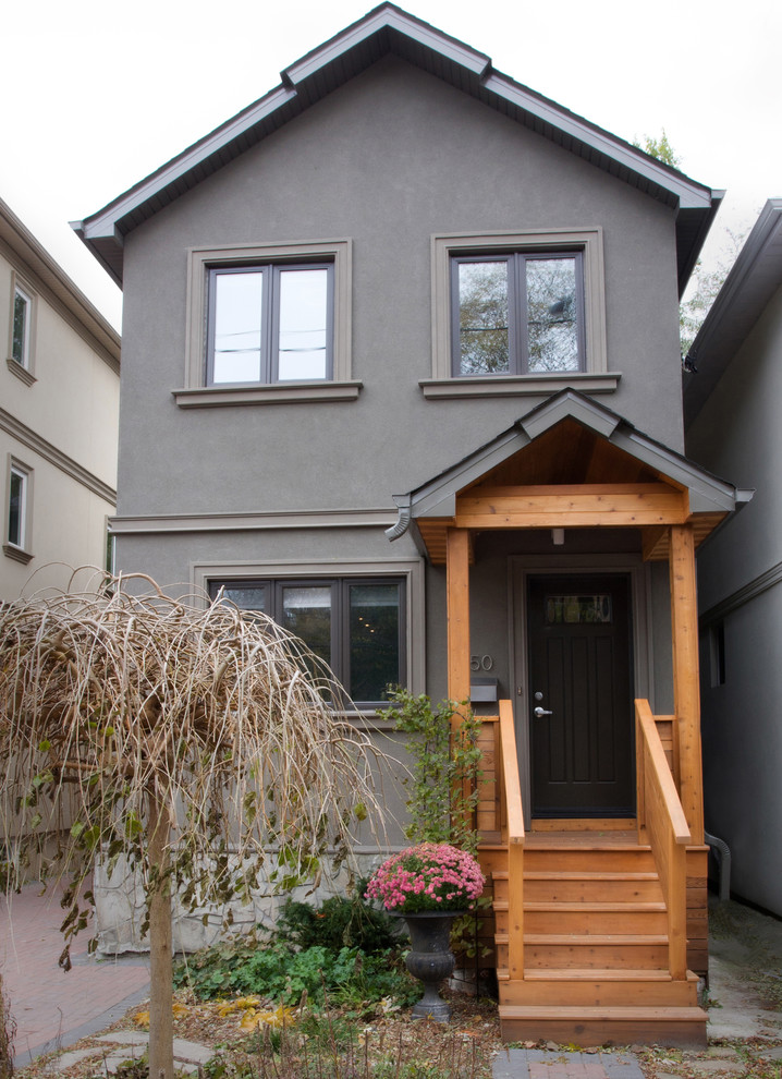 Inspiration for a mid-sized modern two-storey stucco grey exterior in Toronto with a gable roof.