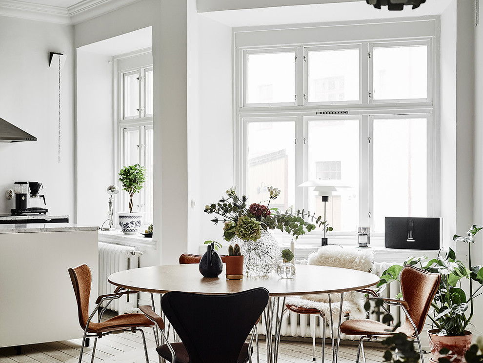 This is an example of a mid-sized scandinavian dining room in Gothenburg with white walls, light hardwood floors and no fireplace.