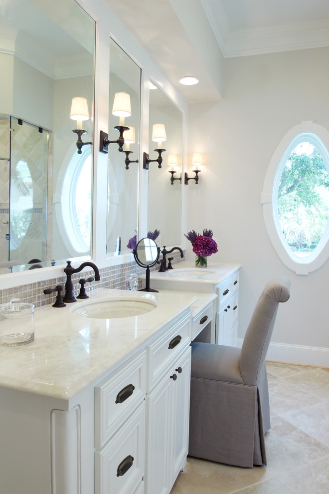 This is an example of a traditional bathroom in Houston with an undermount sink, white cabinets, beige tile, mosaic tile and white benchtops.