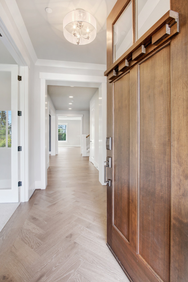 シアトルにあるラグジュアリーな広いコンテンポラリースタイルのおしゃれな玄関ドア (白い壁、淡色無垢フローリング、濃色木目調のドア、茶色い床、折り上げ天井) の写真
