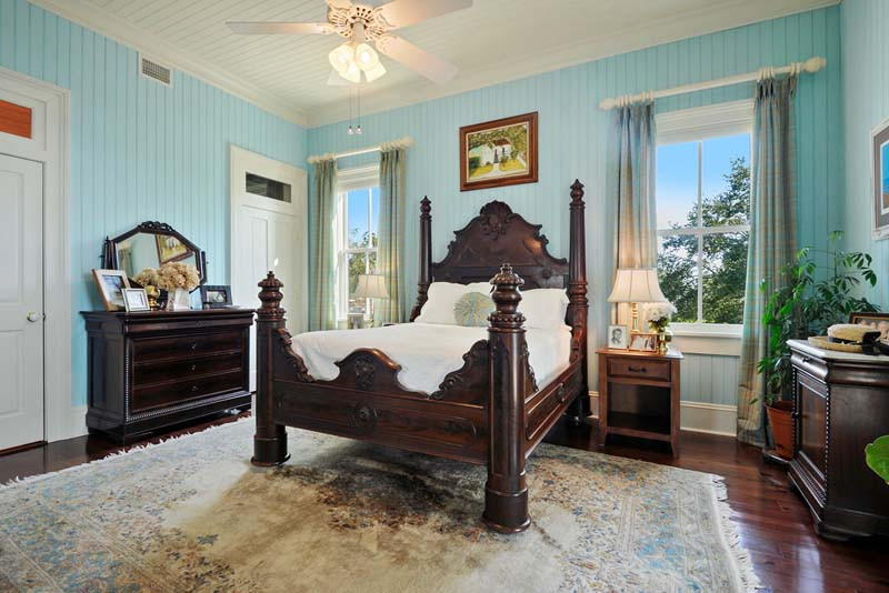 Photo of a mid-sized traditional guest bedroom in New Orleans with blue walls, dark hardwood floors, wood and wood walls.