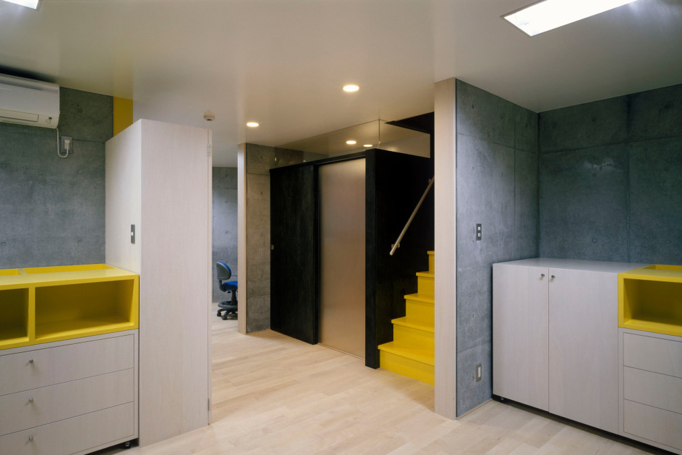 Exempel på ett litet modernt könsneutralt småbarnsrum kombinerat med lekrum, med grå väggar, ljust trägolv och beiget golv