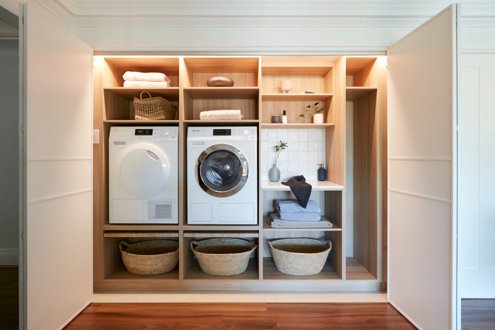 Photo of a small contemporary single-wall dedicated laundry room in Sydney with shaker cabinets, white cabinets, white splashback, ceramic splashback, ceramic floors, a side-by-side washer and dryer, white floor and white benchtop.