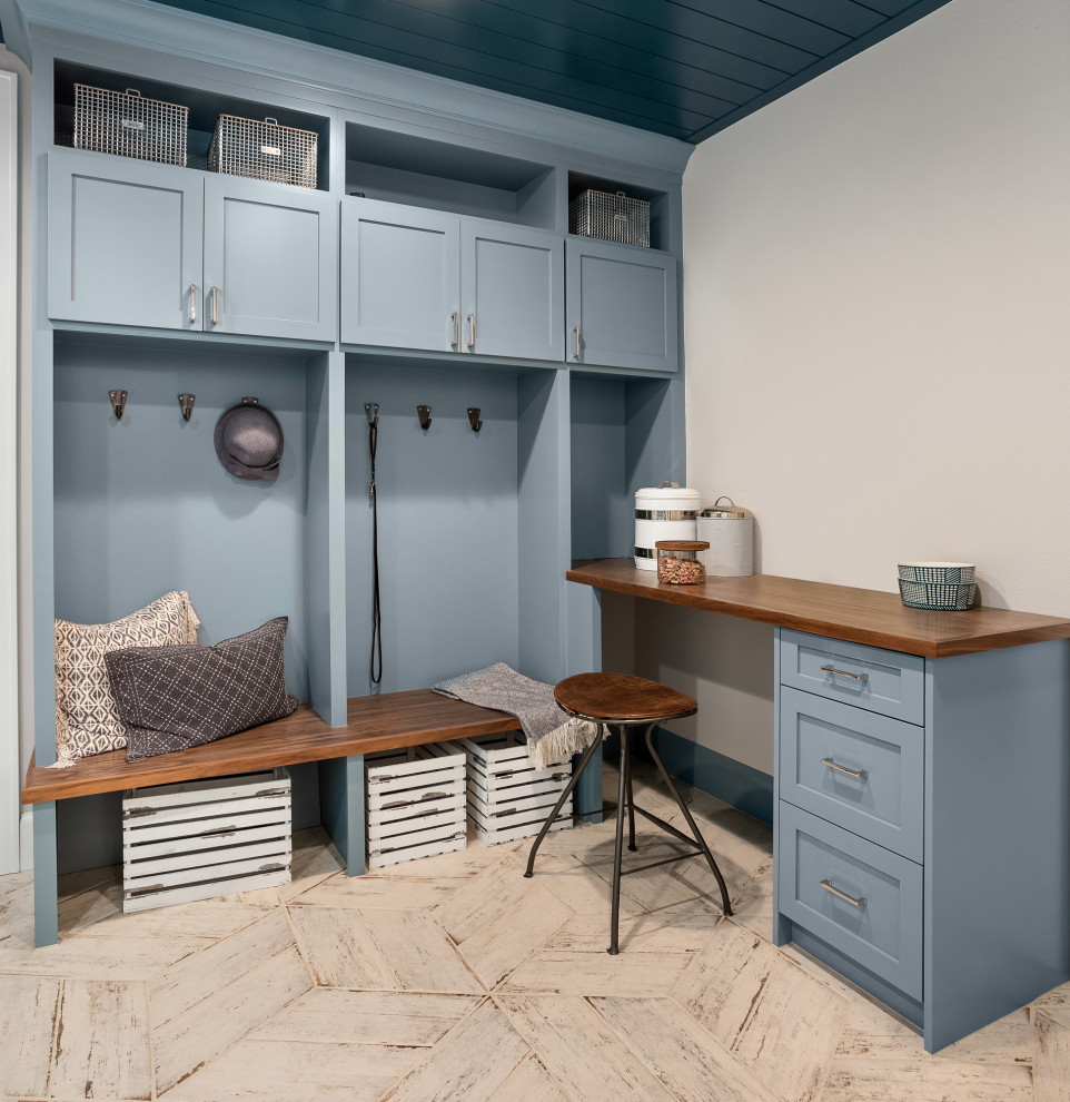 Idéer för en stor lantlig bruna tvättstuga, med blå skåp, träbänkskiva, blått stänkskydd, stänkskydd i keramik, grå väggar, klinkergolv i keramik och grått golv