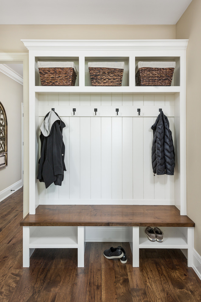 This is an example of a large traditional mudroom in Chicago with beige walls, dark hardwood floors and brown floor.