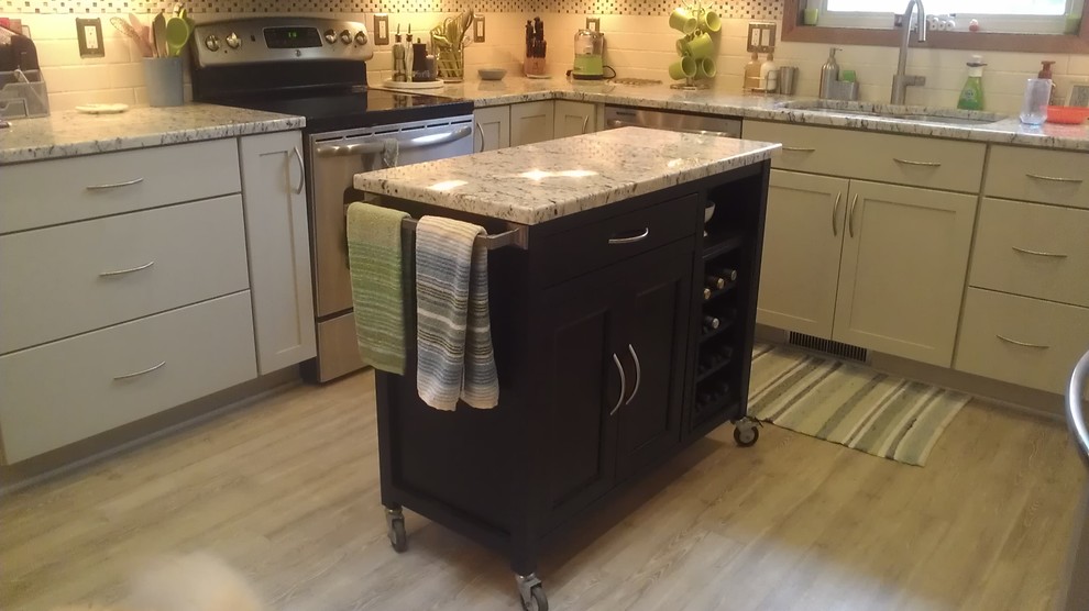 Mid-sized transitional u-shaped vinyl floor eat-in kitchen photo with an undermount sink, shaker cabinets, white cabinets, granite countertops, white backsplash, subway tile backsplash, stainless steel appliances and an island