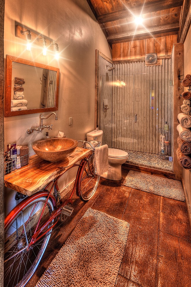 Mid-sized country 3/4 bathroom in Other with open cabinets, beige cabinets, an alcove shower, a two-piece toilet, gray tile, metal tile, beige walls, concrete floors, a vessel sink, wood benchtops, brown floor, a hinged shower door and beige benchtops.