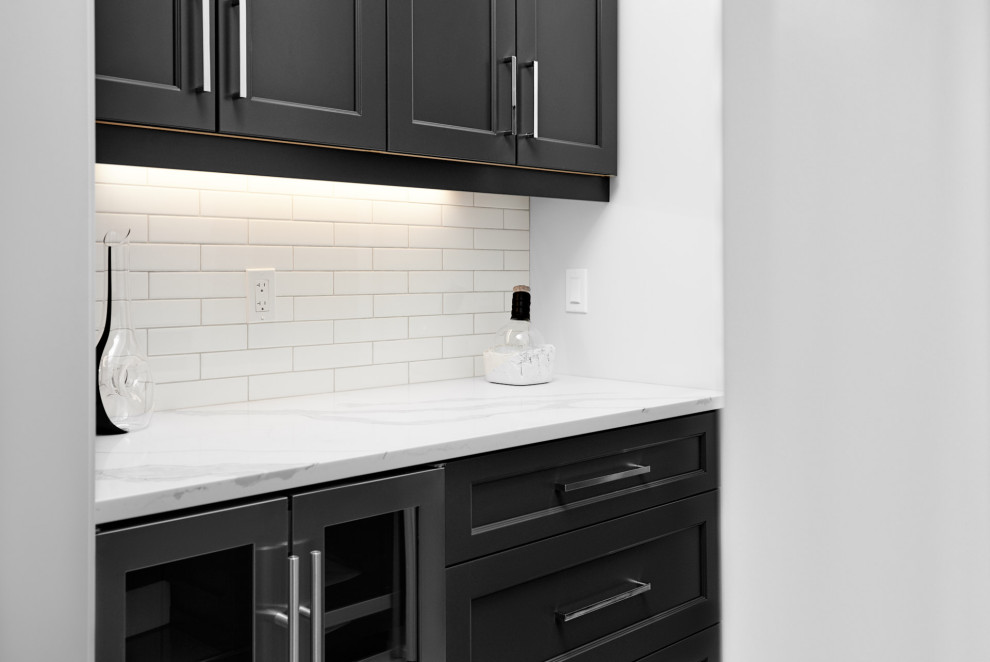 Eat-in kitchen - transitional l-shaped light wood floor and brown floor eat-in kitchen idea in Toronto with an undermount sink, shaker cabinets, black cabinets, marble countertops, white backsplash, subway tile backsplash, stainless steel appliances, an island and white countertops