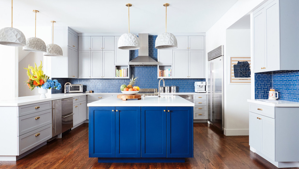 Example of a large trendy u-shaped dark wood floor and brown floor kitchen design in San Francisco with an undermount sink, blue backsplash, ceramic backsplash, stainless steel appliances, an island, white countertops, shaker cabinets and gray cabinets