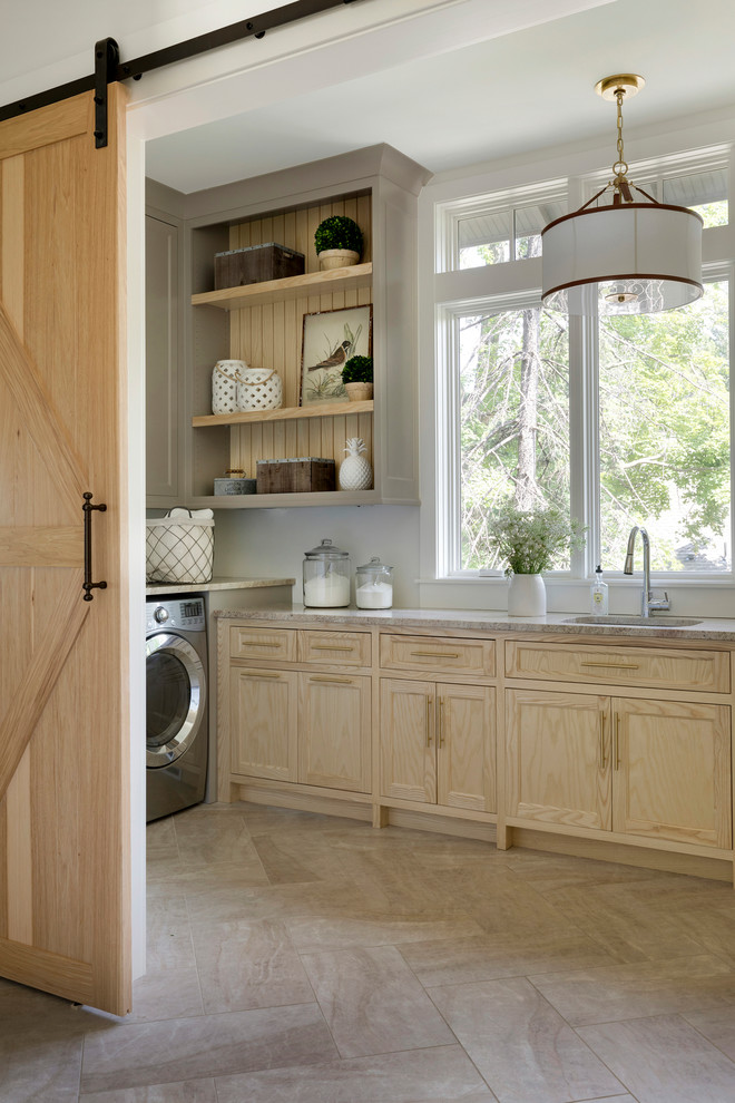 Inspiration for a country l-shaped dedicated laundry room in Minneapolis with an undermount sink, recessed-panel cabinets, light wood cabinets, white walls, a side-by-side washer and dryer, beige floor and beige benchtop.
