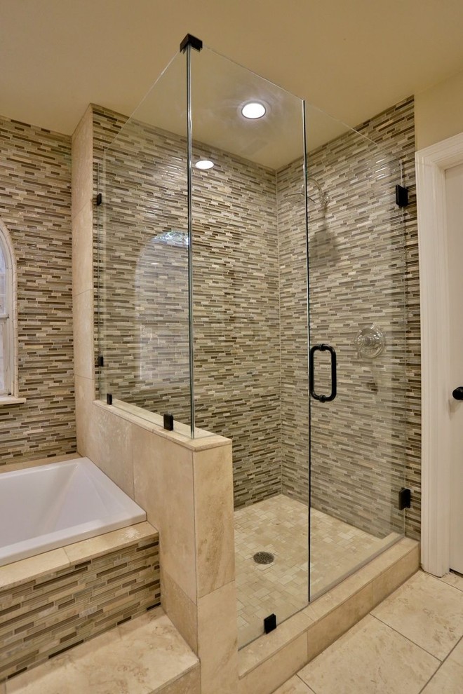 Photo of a large traditional master bathroom in Dallas with an undermount sink, shaker cabinets, light wood cabinets, solid surface benchtops, a drop-in tub, an open shower, a two-piece toilet, beige tile, glass tile, beige walls and travertine floors.