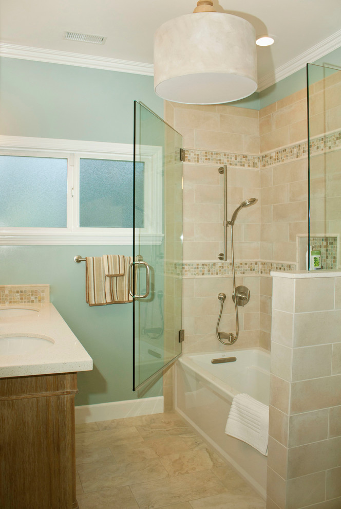 Design ideas for a small beach style 3/4 bathroom in San Francisco with shaker cabinets, medium wood cabinets, a shower/bathtub combo, a one-piece toilet, blue walls, travertine floors, an undermount sink, engineered quartz benchtops, an alcove tub, beige tile, porcelain tile, beige floor and a hinged shower door.