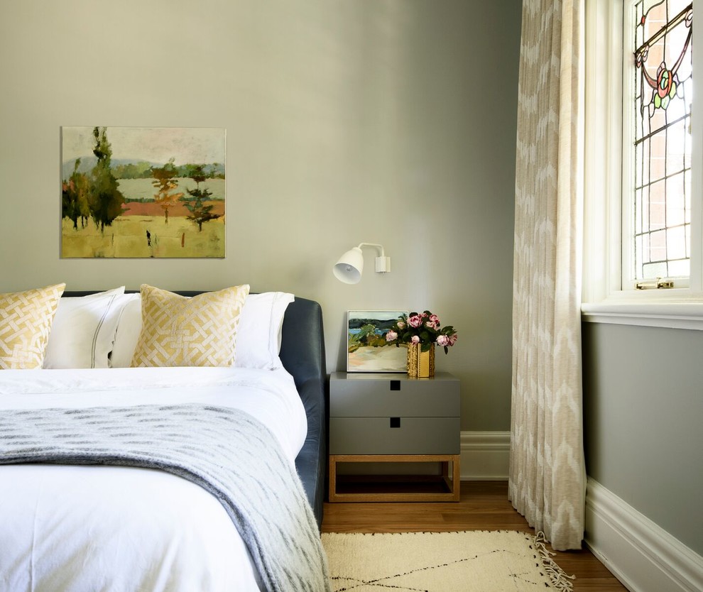Photo of a bedroom in Sydney with grey walls and light hardwood floors.