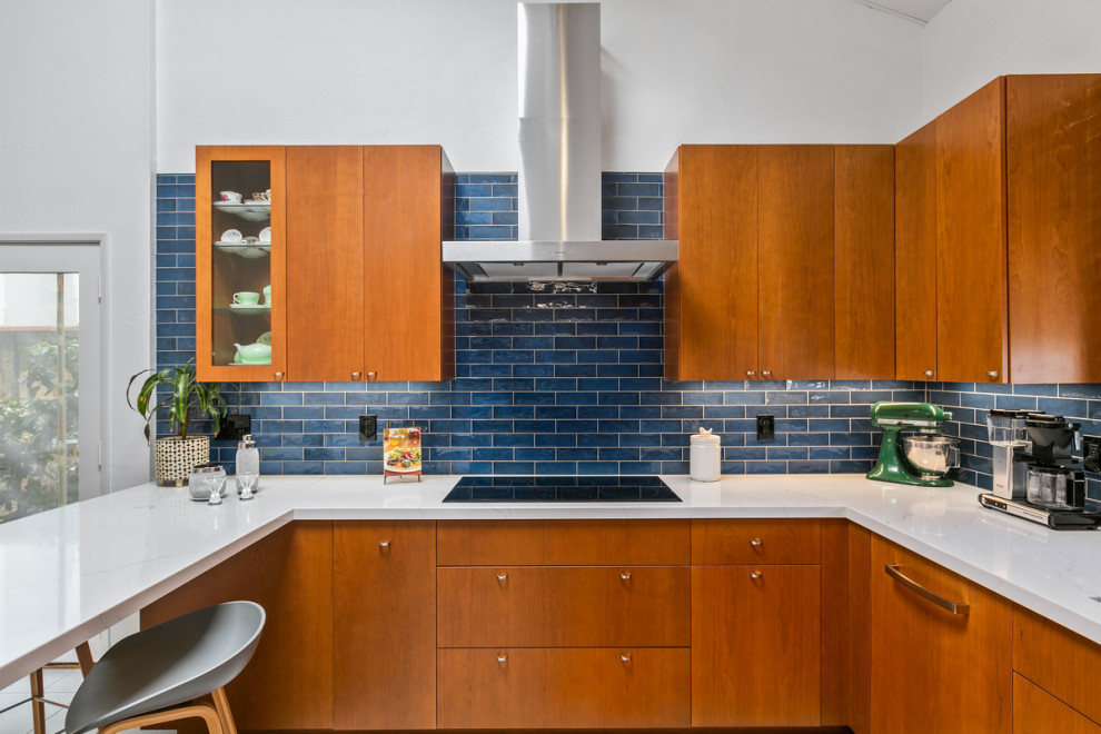 Design ideas for a large midcentury u-shaped eat-in kitchen in San Diego with an undermount sink, flat-panel cabinets, medium wood cabinets, quartz benchtops, blue splashback, ceramic splashback, stainless steel appliances, porcelain floors, grey floor, white benchtop and vaulted.