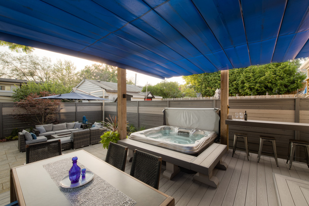 Photo of a mid-sized modern backyard deck in Toronto with an awning.