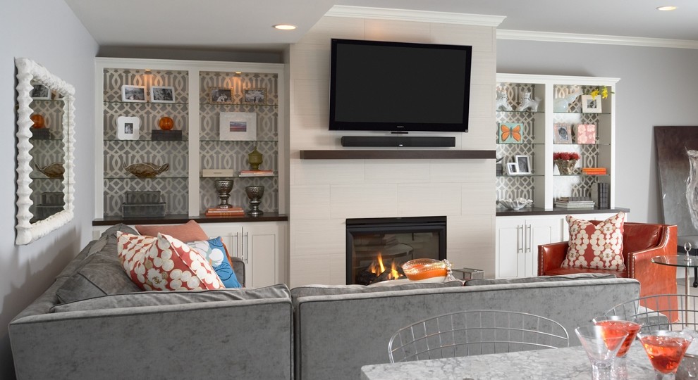 Inspiration for a transitional family room in Minneapolis with grey walls, carpet, a standard fireplace, a wall-mounted tv and a tile fireplace surround.