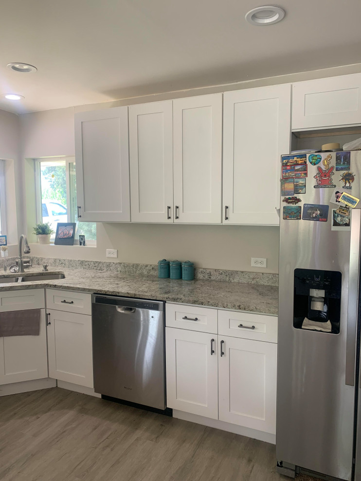Inspiration for a mid-sized transitional u-shaped vinyl floor and gray floor eat-in kitchen remodel in Chicago with a double-bowl sink, shaker cabinets, white cabinets, granite countertops, stainless steel appliances, an island and multicolored countertops