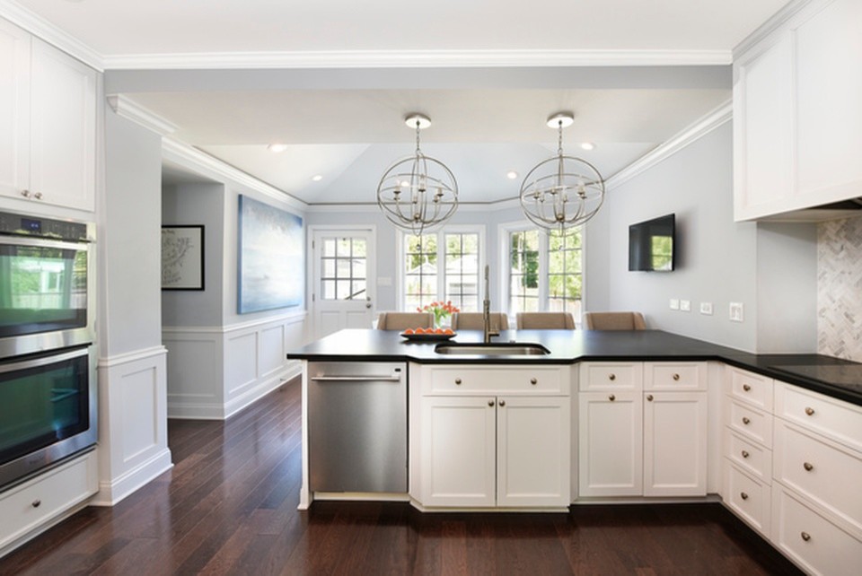 Eat-in kitchen - mid-sized transitional u-shaped dark wood floor and brown floor eat-in kitchen idea in Chicago with an undermount sink, recessed-panel cabinets, white cabinets, quartz countertops, white backsplash, marble backsplash, stainless steel appliances, a peninsula and black countertops