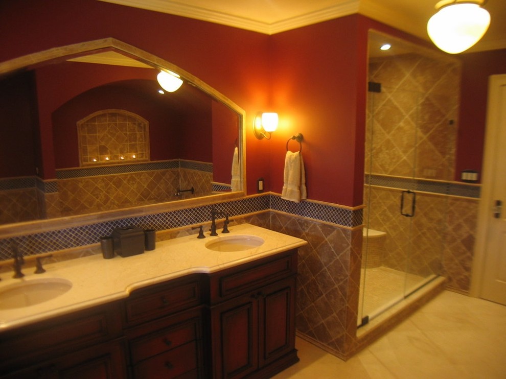 Inspiration for a mid-sized mediterranean master beige tile and stone tile marble floor, beige floor, double-sink and tray ceiling bathroom remodel in New York with an undermount sink, dark wood cabinets, marble countertops, a two-piece toilet, beige walls, furniture-like cabinets, a hinged shower door, beige countertops and a freestanding vanity