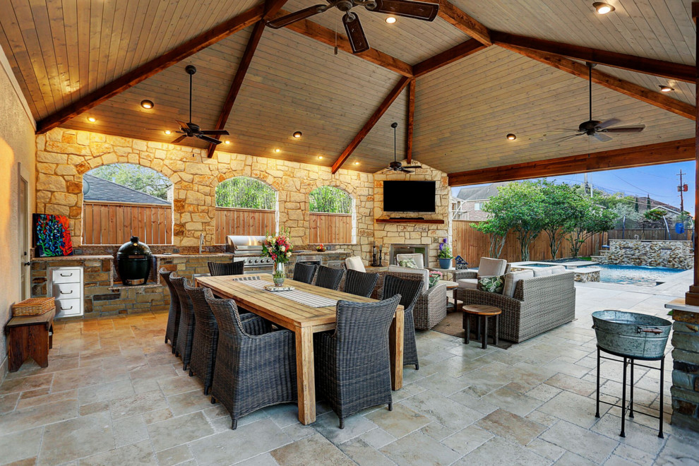Inspiration for a large traditional backyard patio in Houston with an outdoor kitchen, natural stone pavers and a roof extension.
