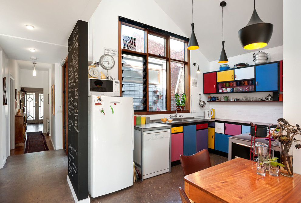 Design ideas for a mid-sized eclectic u-shaped eat-in kitchen in Melbourne with flat-panel cabinets, white appliances, a single-bowl sink, laminate benchtops, concrete floors, no island, grey floor and red benchtop.
