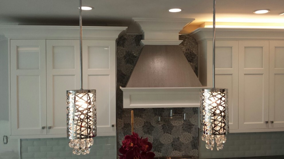 Mid-sized transitional l-shaped kitchen photo in New York with shaker cabinets, white cabinets, an undermount sink, marble countertops, glass tile backsplash, stainless steel appliances and an island