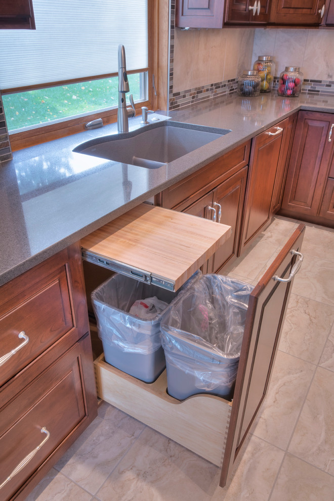 Large transitional l-shaped ceramic tile eat-in kitchen photo with an undermount sink, raised-panel cabinets, medium tone wood cabinets, multicolored backsplash, mosaic tile backsplash, paneled appliances, an island and recycled glass countertops