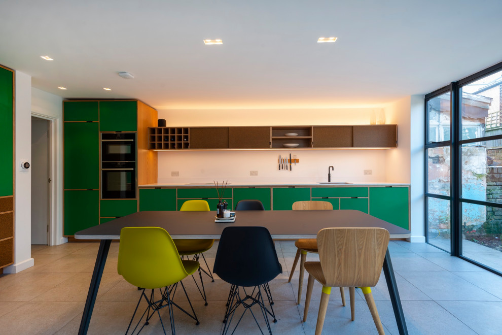 This is an example of a medium sized scandinavian single-wall kitchen/diner in London with an integrated sink, recessed-panel cabinets, green cabinets, integrated appliances, porcelain flooring, no island, grey floors and white worktops.